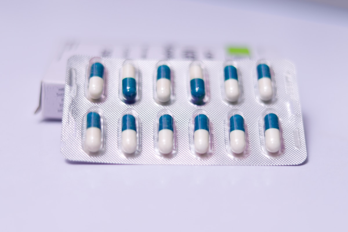 Blister de capsules pharmaceutiques bleues et blanches.