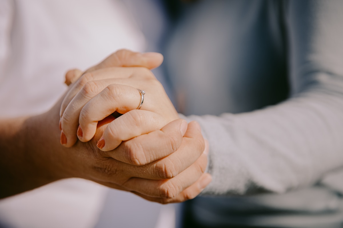 Mains jointes, bague de fiançailles, geste d'affection.
