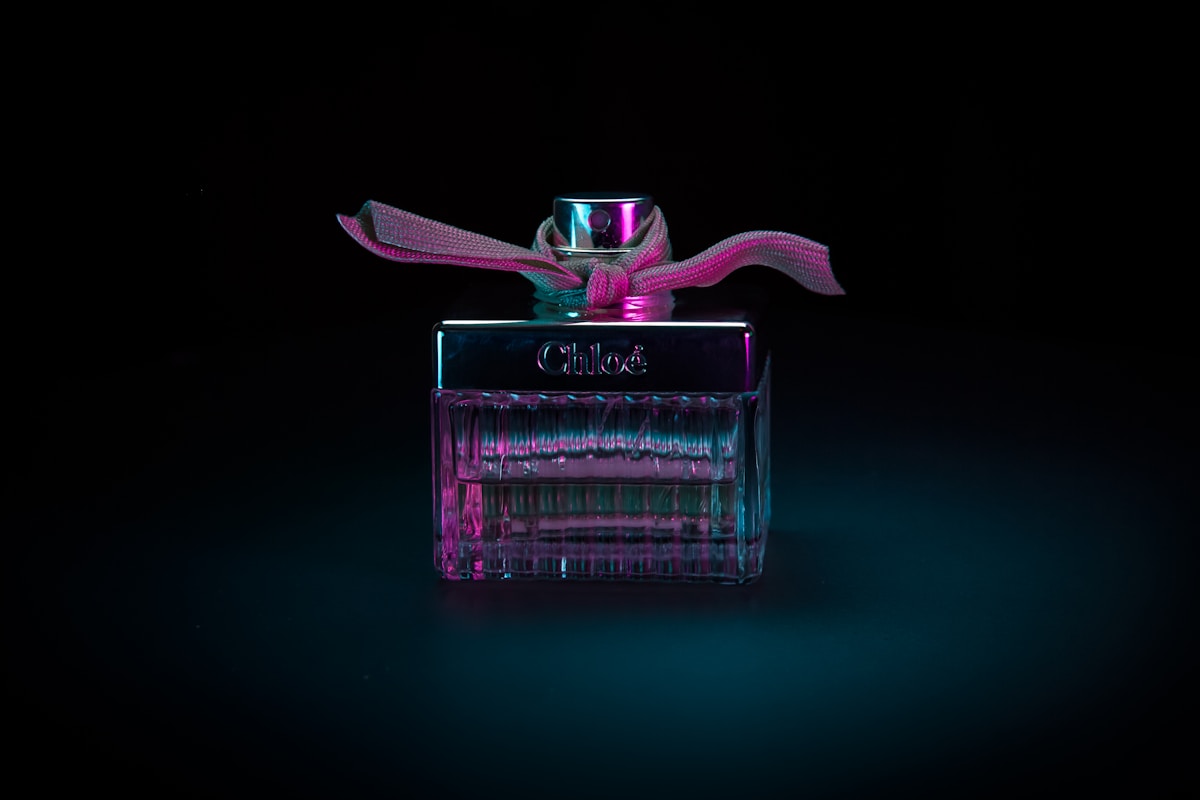 Flacon de parfum Chloé rose et bleu sur fond noir.
