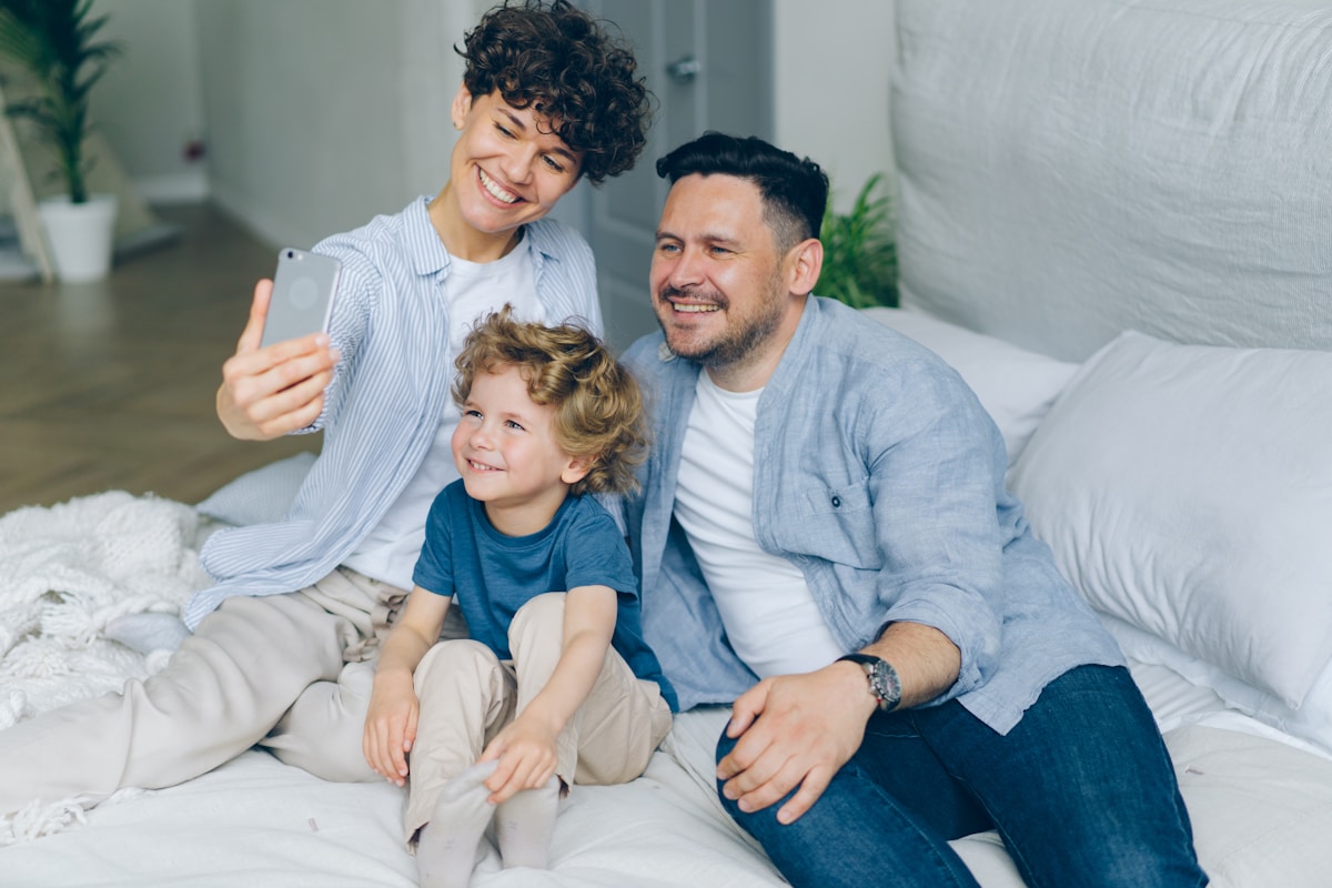 Famille heureuse prenant un selfie ensemble dans leur maison.