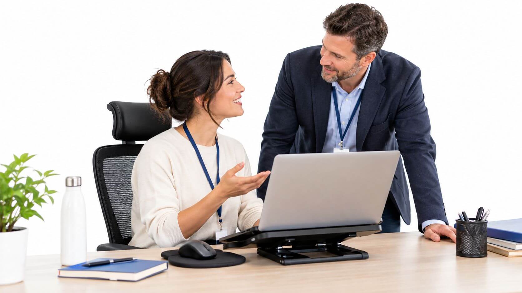 A woman and a man discussing work professionally in front of a laptop on a desk