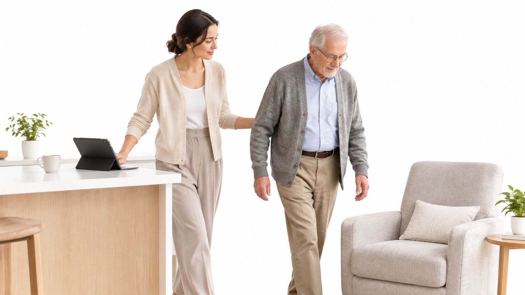 A home helper accompanies an elderly man walking to an armchair in a modern living room.
